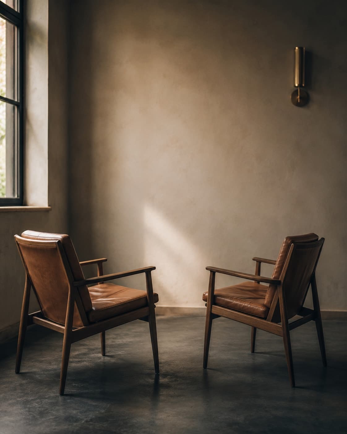 Twee leren fauteuils tegenover elkaar in een lege ruimte